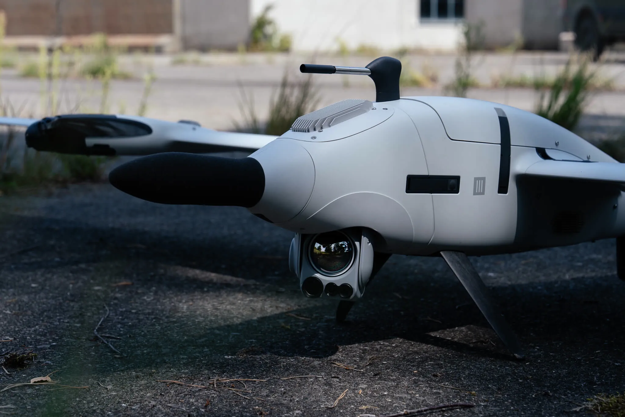 A Quantum Systems Vector fixed-wing VTOL on the ground, with a gimballed camera mounted beneath the nose